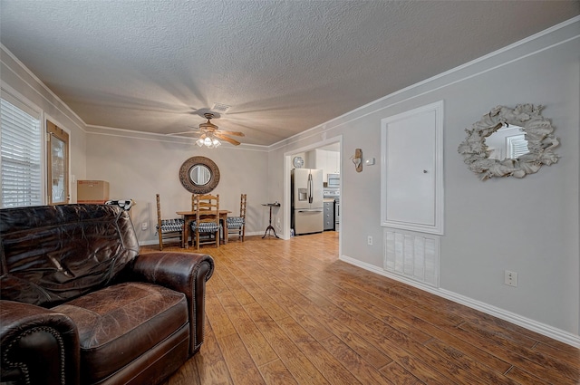 living room featuring ornamental molding, hardwood / wood-style floors, a textured ceiling, and ceiling fan