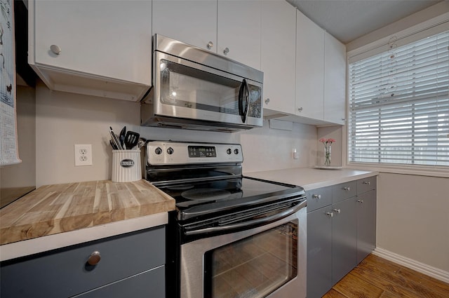 kitchen featuring gray cabinetry, hardwood / wood-style floors, stainless steel appliances, and white cabinets