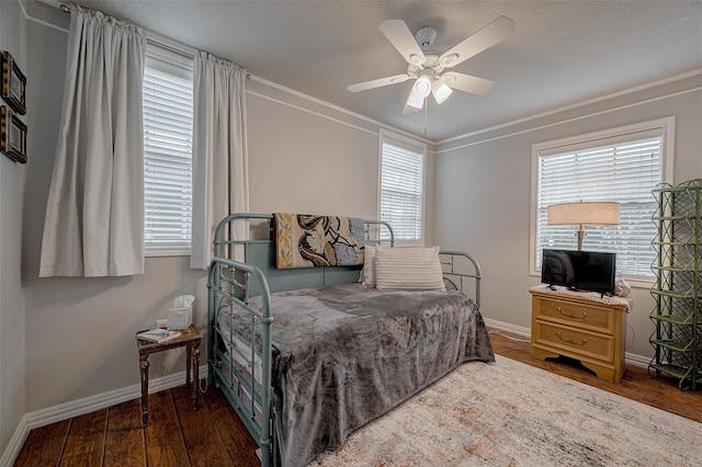 bedroom featuring dark wood-type flooring, ceiling fan, and ornamental molding