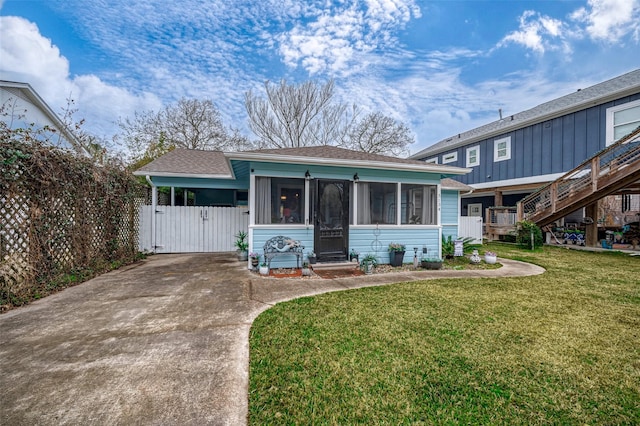 view of front of house with a front lawn and a sunroom