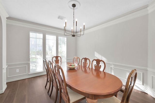 dining area featuring an inviting chandelier, dark hardwood / wood-style flooring, and crown molding