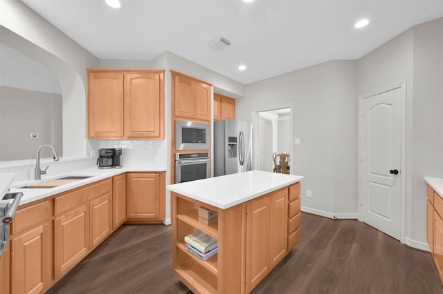 kitchen with a center island, light brown cabinets, dark hardwood / wood-style flooring, stainless steel appliances, and sink