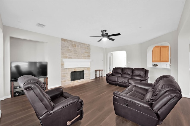 living room with ceiling fan, dark hardwood / wood-style floors, and a fireplace