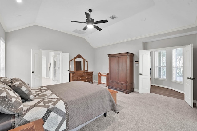 carpeted bedroom with ceiling fan, crown molding, and lofted ceiling