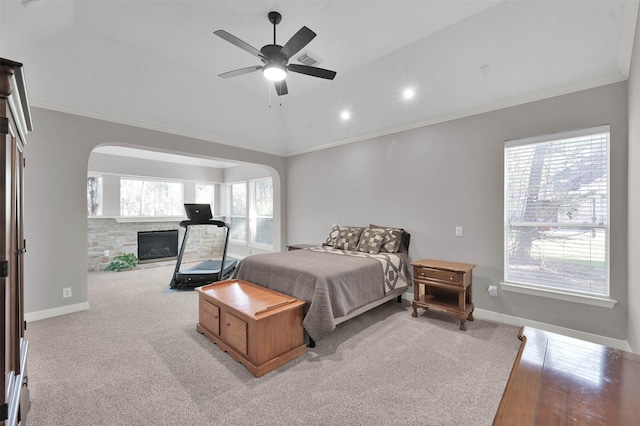 bedroom with ceiling fan, light colored carpet, a fireplace, and crown molding