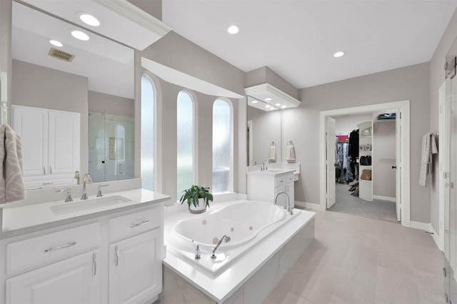 bathroom featuring tile patterned floors, vanity, and shower with separate bathtub