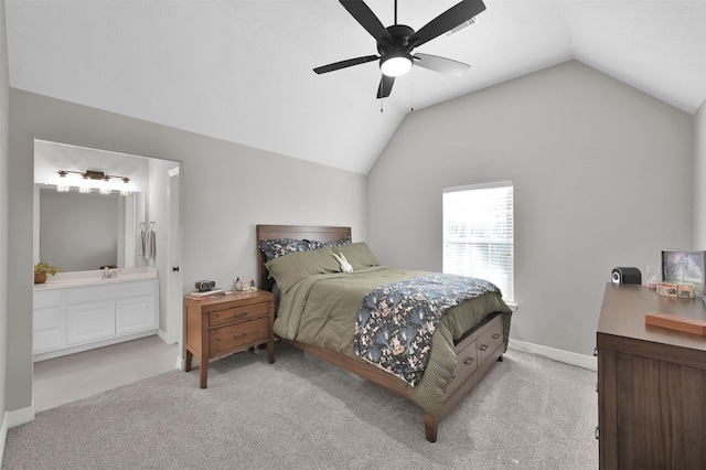 bedroom with ceiling fan, connected bathroom, light carpet, and vaulted ceiling