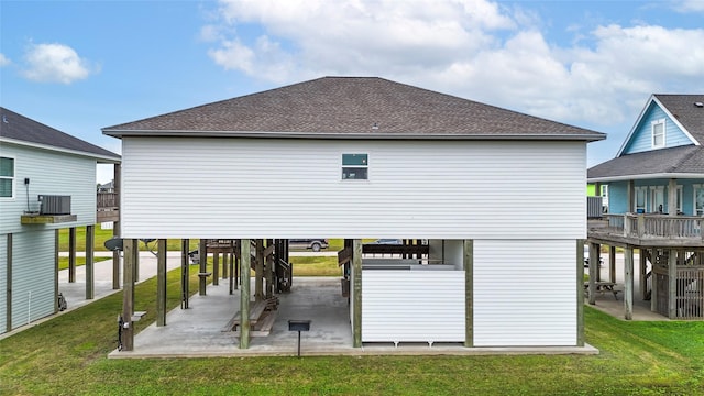 rear view of house with cooling unit and a lawn