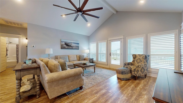 living room featuring high vaulted ceiling, a wealth of natural light, beamed ceiling, and light hardwood / wood-style floors