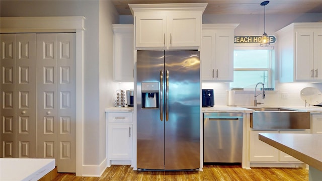 kitchen with white cabinetry, stainless steel appliances, and backsplash