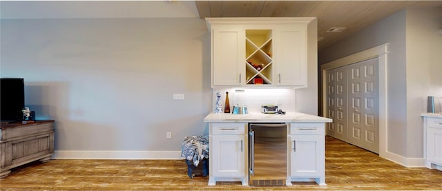 kitchen featuring backsplash, refrigerator, light hardwood / wood-style floors, white cabinetry, and wooden ceiling