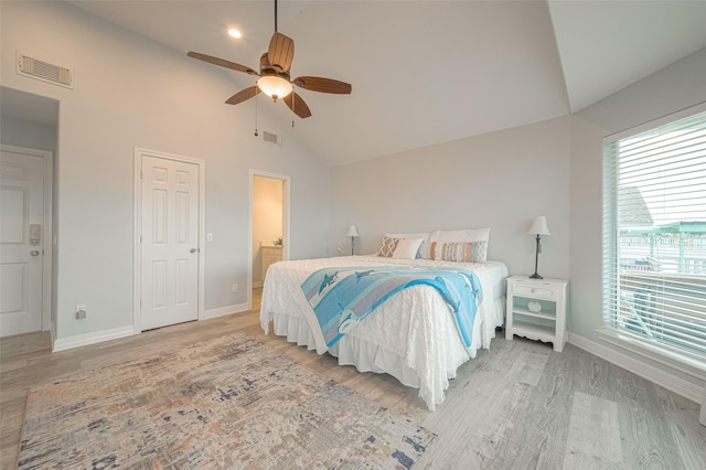 bedroom with ceiling fan, multiple windows, and light wood-type flooring