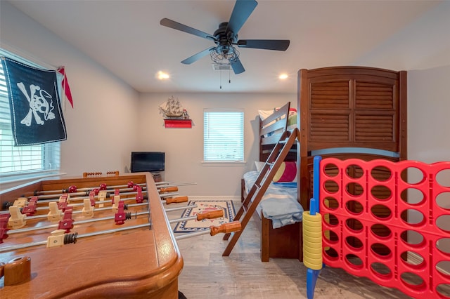 bedroom featuring ceiling fan, multiple windows, and wood-type flooring