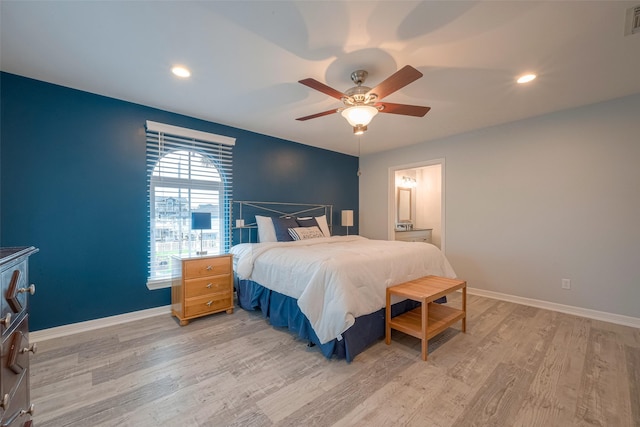 bedroom featuring ceiling fan, light hardwood / wood-style floors, and connected bathroom