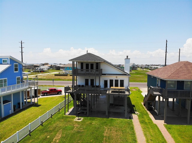 back of property featuring a yard, a patio area, fence, and a balcony