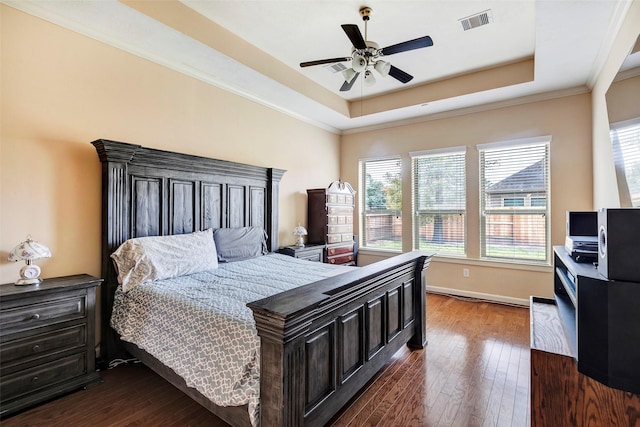 bedroom featuring a raised ceiling, ceiling fan, dark hardwood / wood-style floors, and crown molding