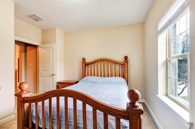 carpeted bedroom featuring multiple windows