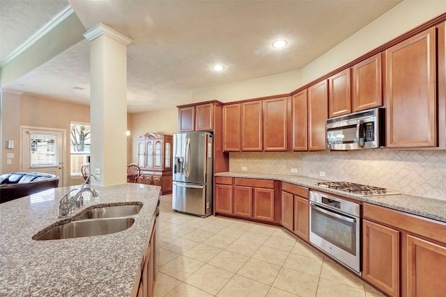 kitchen featuring decorative backsplash, sink, stainless steel appliances, and decorative columns