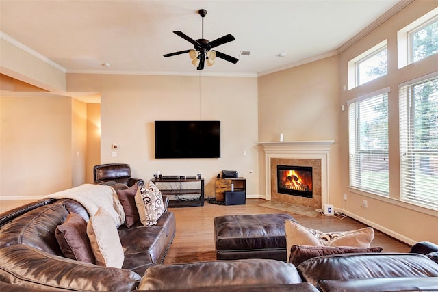 living room with ceiling fan, a fireplace, and crown molding