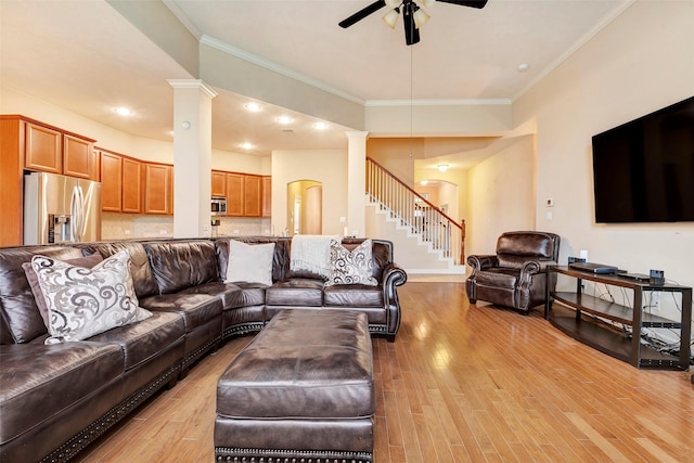 living room featuring ornate columns, ornamental molding, and light hardwood / wood-style flooring