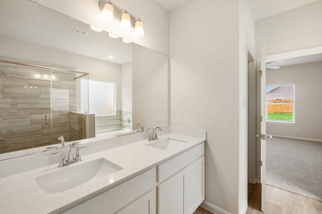 bathroom featuring hardwood / wood-style floors, vanity, and shower with separate bathtub