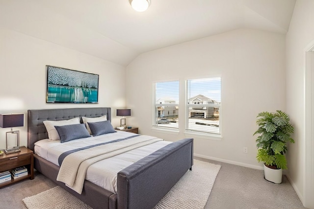 bedroom with light colored carpet and vaulted ceiling