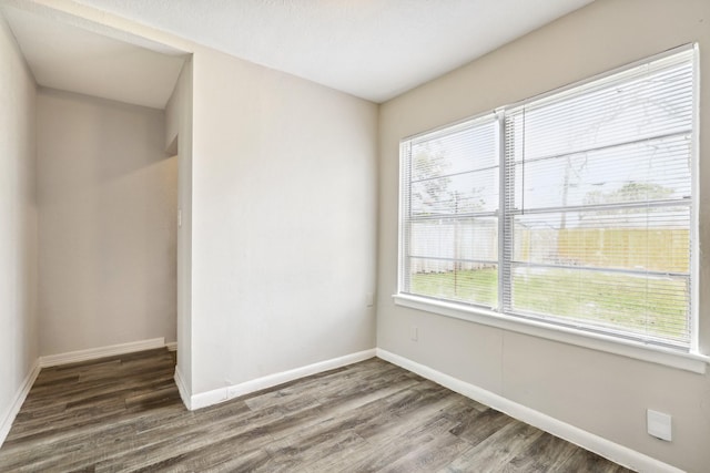 unfurnished room featuring wood finished floors and baseboards