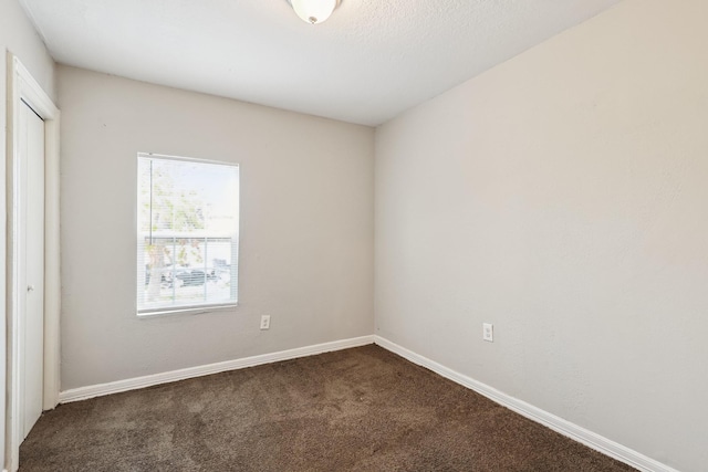 carpeted spare room featuring baseboards