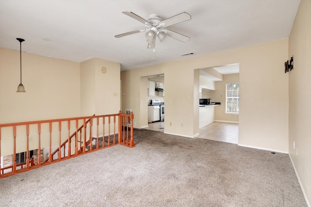 spare room featuring light carpet and ceiling fan