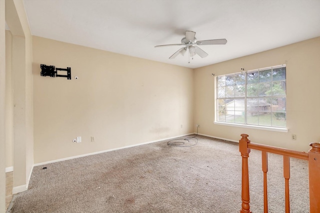 carpeted spare room with ceiling fan