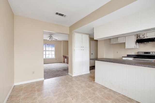 kitchen featuring white cabinets, stainless steel range with electric cooktop, kitchen peninsula, ceiling fan, and light tile patterned floors