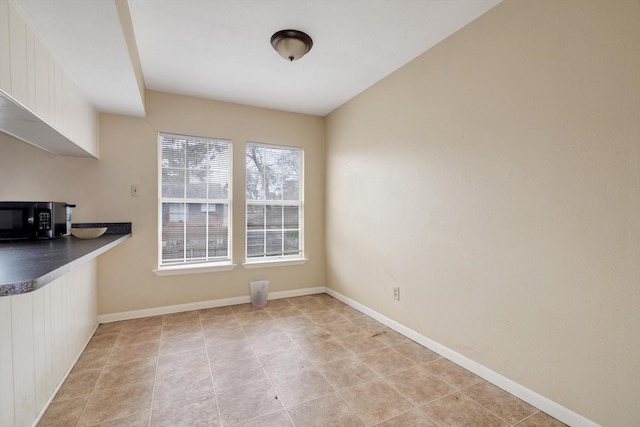 unfurnished dining area featuring light tile patterned flooring