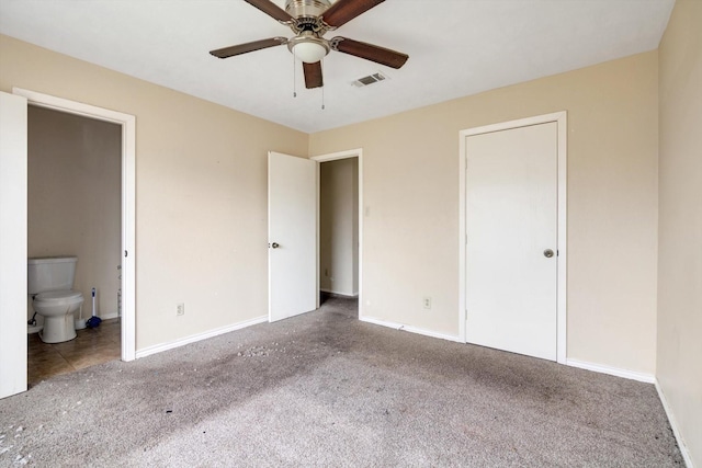 unfurnished bedroom with ceiling fan, ensuite bath, and carpet flooring