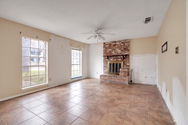 unfurnished living room with ceiling fan, light tile patterned flooring, and a fireplace