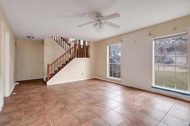 empty room with ceiling fan and tile patterned flooring