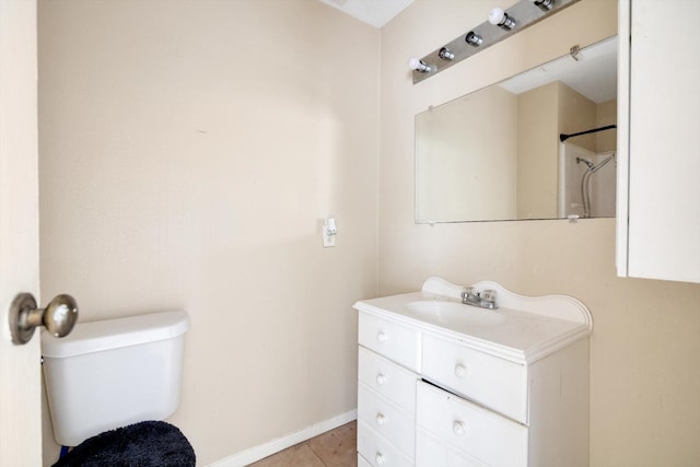 bathroom with toilet, vanity, and tile patterned floors