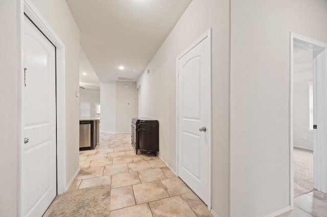 hallway featuring light colored carpet