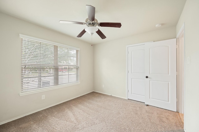 unfurnished bedroom with ceiling fan, a closet, and light carpet