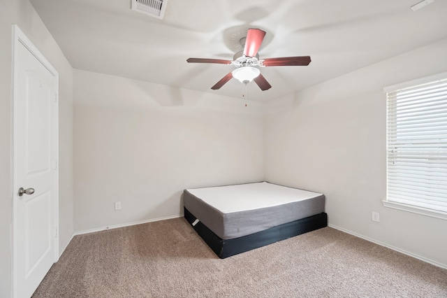 unfurnished bedroom featuring ceiling fan, carpet flooring, and multiple windows