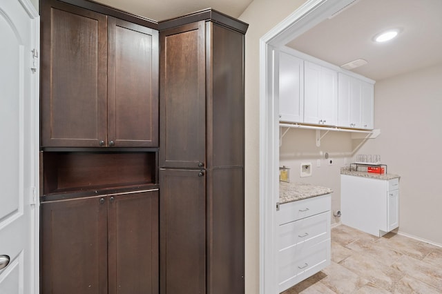 interior space with cabinets, hookup for a washing machine, and hookup for an electric dryer