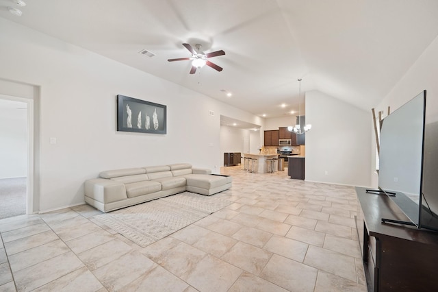 living room featuring vaulted ceiling and ceiling fan with notable chandelier