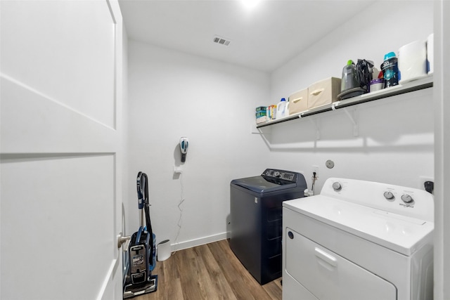 washroom with washer and dryer and light hardwood / wood-style flooring