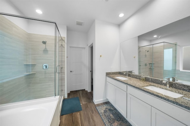 bathroom with hardwood / wood-style floors, vanity, and shower with separate bathtub