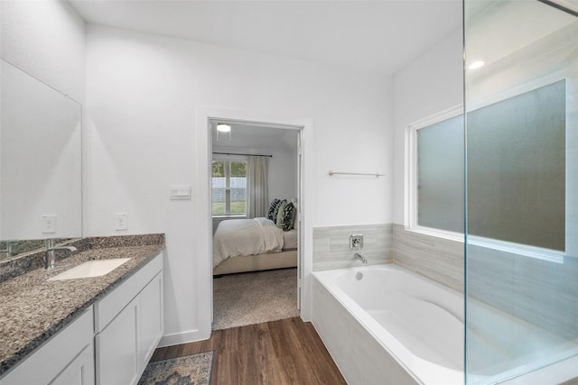 bathroom with a bath, hardwood / wood-style flooring, and vanity