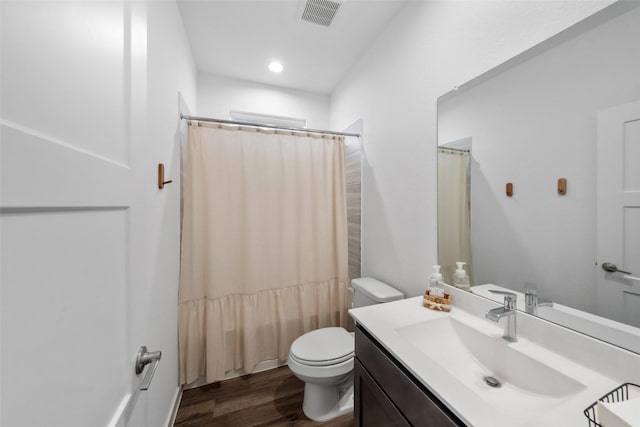 full bathroom with hardwood / wood-style floors, toilet, vanity, and shower / tub combo with curtain