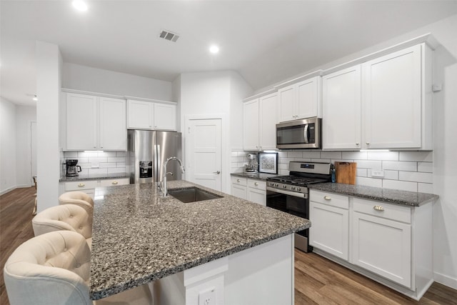 kitchen featuring appliances with stainless steel finishes, a kitchen island with sink, white cabinetry, and sink