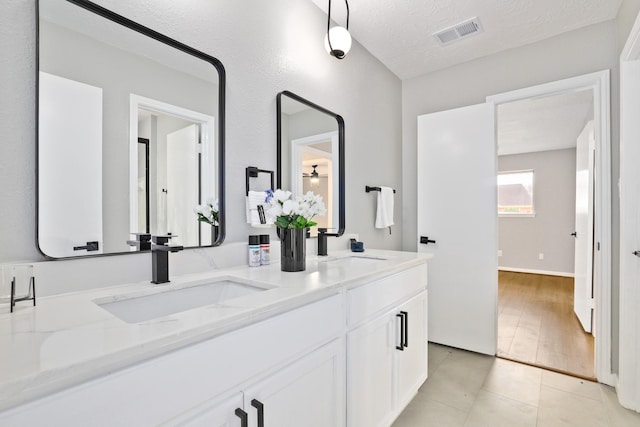 bathroom featuring vanity, tile patterned flooring, and a textured ceiling