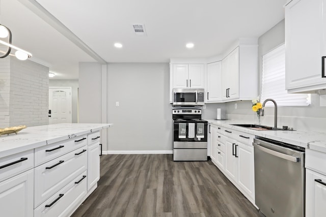 kitchen with appliances with stainless steel finishes, dark hardwood / wood-style floors, sink, white cabinets, and light stone countertops