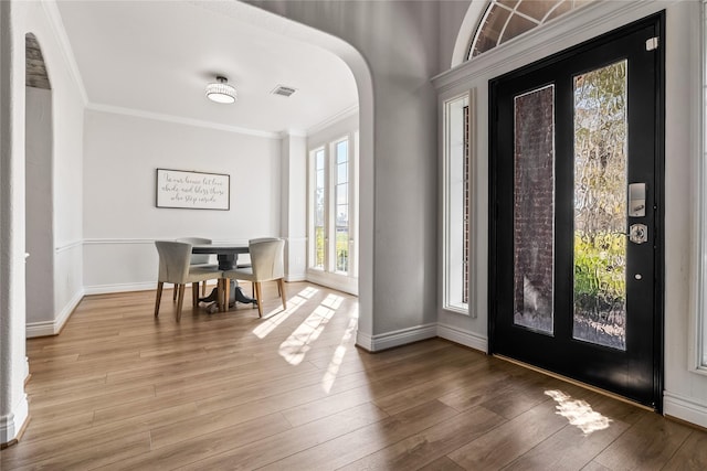 entryway featuring hardwood / wood-style floors and crown molding