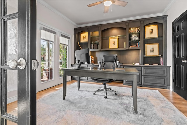 home office featuring light wood-type flooring, ceiling fan, and ornamental molding